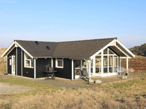 a black and white house with a large deck at Tranquil Retreat in Klitmoller - By Traum Ferienwohnungen in Klitmøller