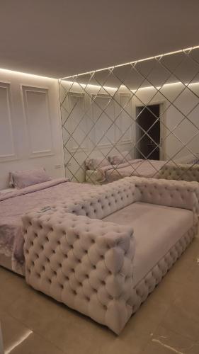 a large white bed in a room with a mirror at villa pools bbq lounge in Oujda