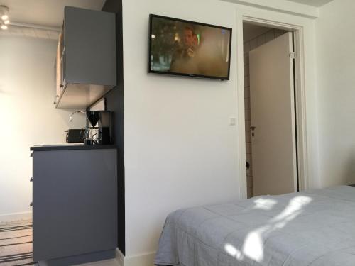 a bedroom with a flat screen tv on a wall at Dragondrum Bed & Kitchen in Ullerslev