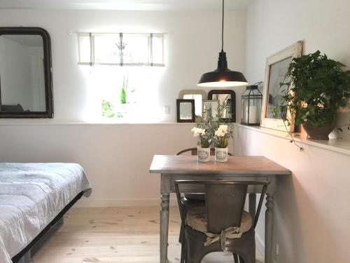a bedroom with a table with flowers on it at Dragondrum Bed & Kitchen in Ullerslev