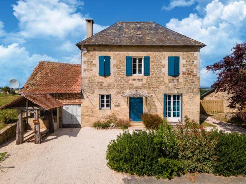 an old stone house with blue shutters on it at Holiday home with pool in Coubjours in Coubjours