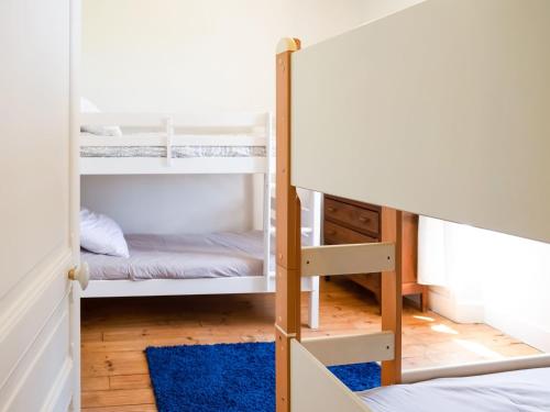 a bunk bed room with two bunk beds and a blue rug at Holiday home with pool in Coubjours in Coubjours
