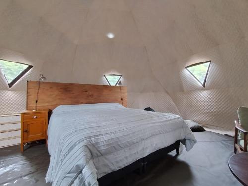 a bedroom with a large bed in a room with windows at LA Viella Glamp Tala in Mar del Plata