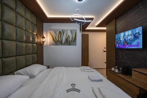 a bedroom with a bed and a flat screen tv at Etno selo Raduške staze in Tutin
