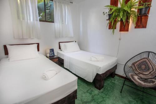 a room with two beds and a chair in it at Villas Jacquelina in Quepos