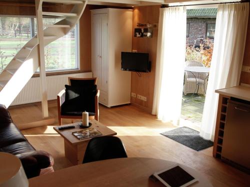 a living room with a staircase and a television at Apartment in Heiloo near North Sea Beach in Heiloo