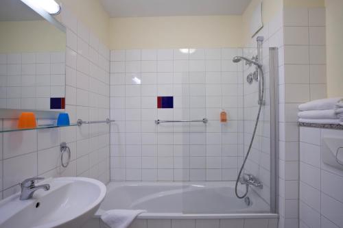 a bathroom with a shower and a tub and a sink at Hotel Hanseport Hamburg in Hamburg