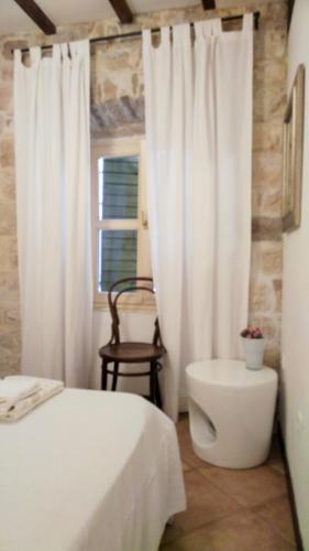 a bedroom with a bed and a toilet and a window at Rooms Livia in Trogir
