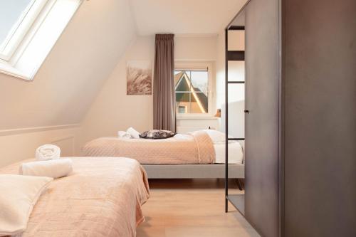 a bedroom with two beds and a window at Beachvilla Royaal met Sauna - 10 personen in Holle Poarte
