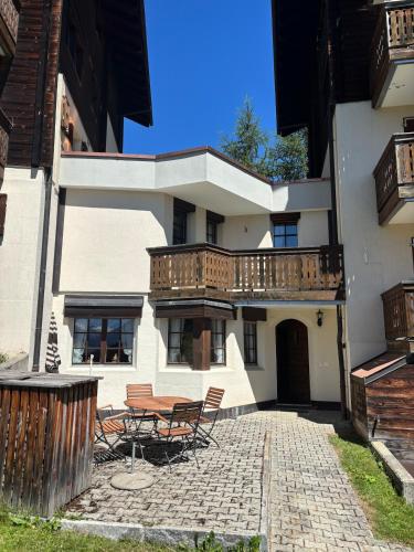 a building with a patio with a table and chairs at Duplexwohnung in den Alpen in Riederalp