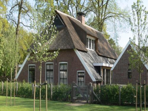 a red brick house with a gambrel roof at Farmhouse Nijverdal near Sallandse Heuvelrug in Nijverdal