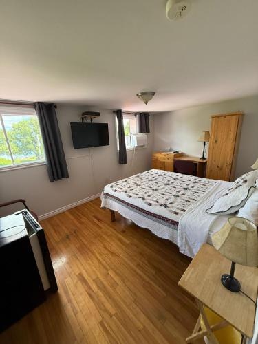 a bedroom with a bed and a television in it at Hostellerie du Suroît in Beauharnois