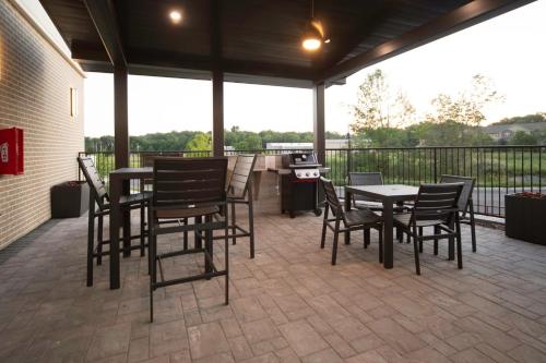 a patio with tables and chairs and a grill at Candlewood Suites Middletown - Goshen by IHG in Middletown