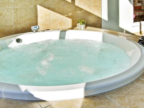 a bath tub filled with blue water in a bathroom at Luxury Pool Retreat in Nordborg - By Traum Ferienwohnungen in Nordborg
