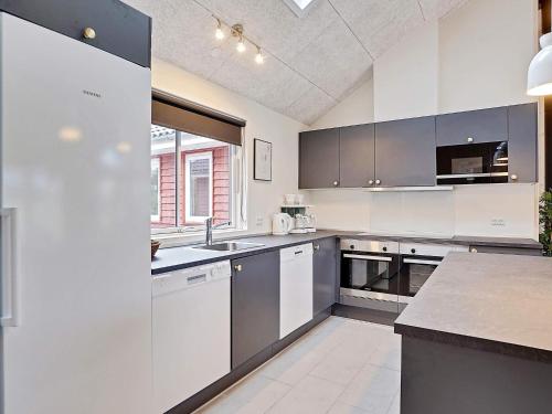 a kitchen with white cabinets and a large window at Luxury Retreat with Pool - By Traum Ferienwohnungen in Grenå