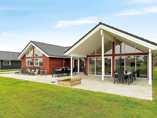 a house with a patio with tables and chairs at Luxury Retreat with Pool - By Traum Ferienwohnungen in Grenå
