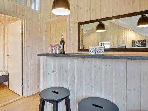 a bar with two stools and a mirror at Luxury Retreat with Pool - By Traum Ferienwohnungen in Grenå