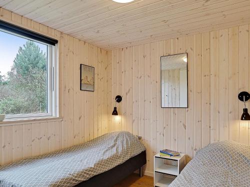 a bedroom with a bed and a mirror and a window at Luxury Retreat with Pool - By Traum Ferienwohnungen in Grenå