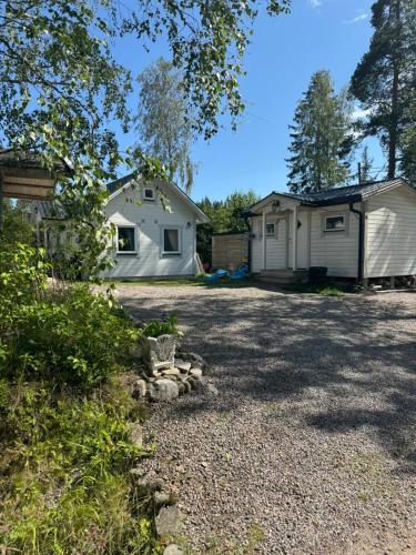 a white house with a garage in the yard at Charming cottage on Kvegero in Gnesta