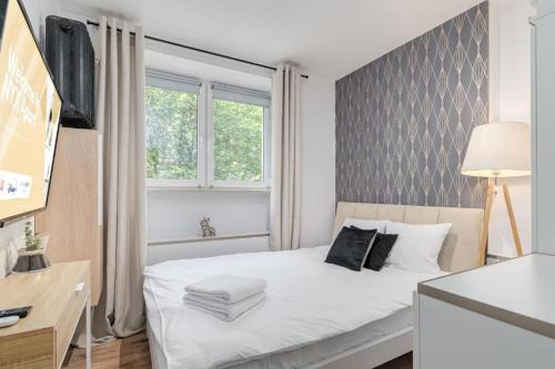 una camera da letto con un letto bianco e una finestra di Złota 77 by NYX Apart a Skorka