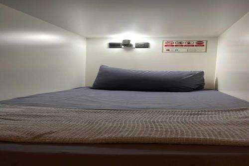 a bedroom with a bed with a blue pillow at OYO 91036 J CAPSULE HOTEL @ JALAN BUKIT BINTANG in Kuala Lumpur