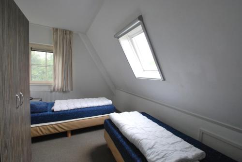 a bedroom with two beds and a window at Beachvilla Royaal Classic met Sauna - 10 personen in Holle Poarte