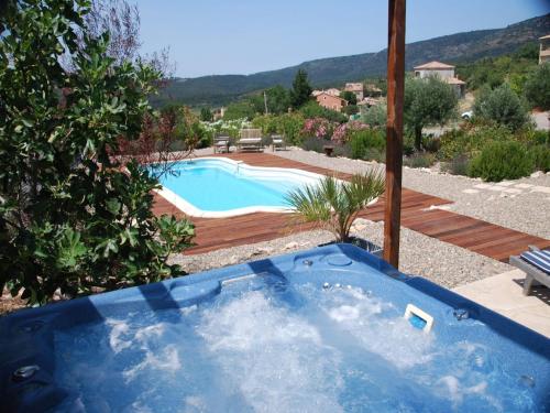 Una bañera azul en un patio con piscina. en Stylish Family Villa in Félines, en Félines-Minervois