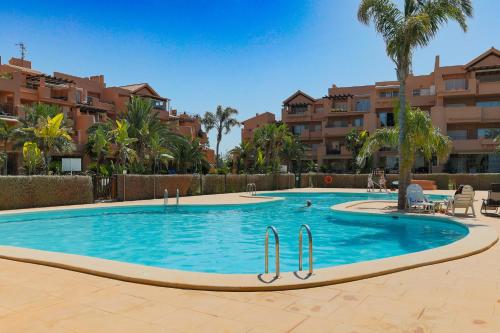 basen w ośrodku z palmami i budynkami w obiekcie Appartement La Casa Soleada Mar Menor Golf & Padel Resort w mieście Torre-Pacheco