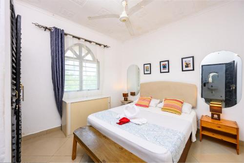 a bedroom with a bed and a tv in it at Little star apartment diani in Mombasa
