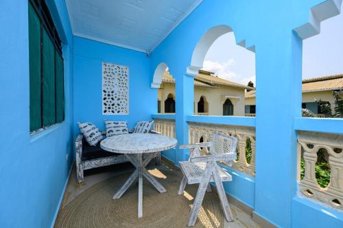 a blue room with a table and chairs on a balcony at Little star apartment diani in Mombasa