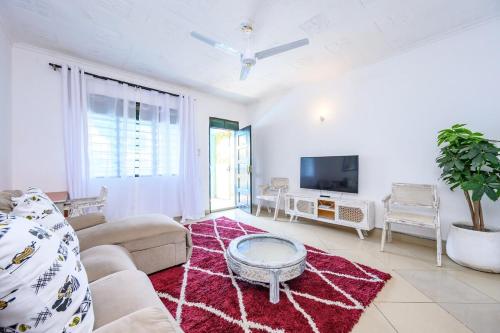 a living room with a couch and a tv at Little star apartment diani in Mombasa