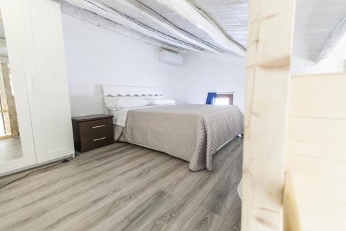 a bedroom with a bed and a wooden floor at B&B del Massimo in Palermo