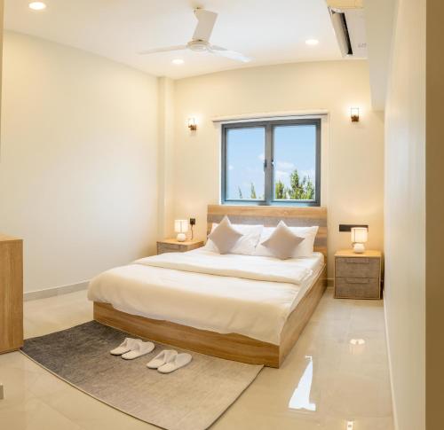 a bedroom with a bed with two lamps and a window at Pulsera Beach Residence Maldives by Circles Hospitality in Hulhumale