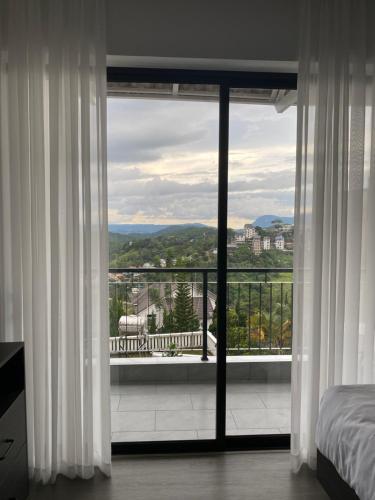 a bedroom with a large window with a view at Famille Hotel - Central hotel in Dalat in Xuan An