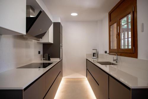 Una cocina con encimeras blancas y un fregadero. en Villa Casa Calonge, en Calonge