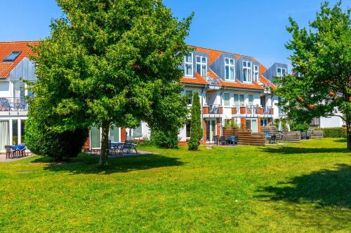 a large building with trees in front of it at Sünnslag Wohnung 049 in Boltenhagen