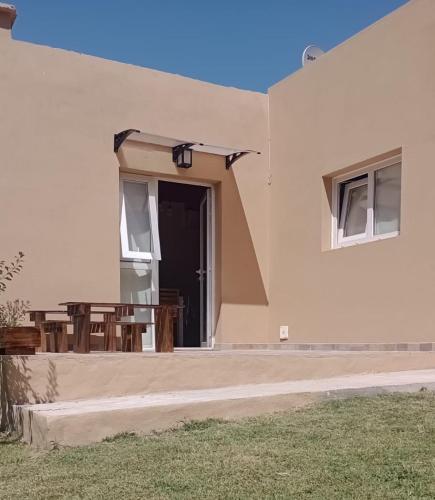 un edificio con un patio con mesa y sillas en Cabaña Ruca Malen, en Tandil