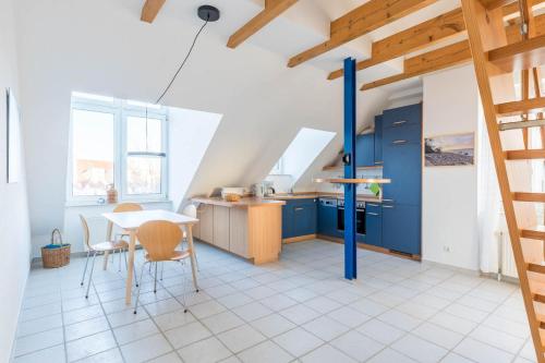 a kitchen with blue cabinets and a table and chairs at Sünnslag Wohnung 129 in Boltenhagen