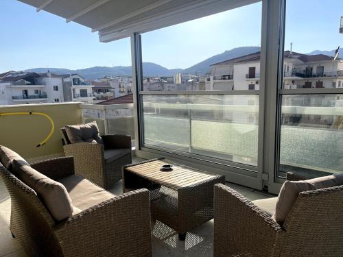 a balcony with chairs and a table and large windows at Skye urban oasis in Tripolis