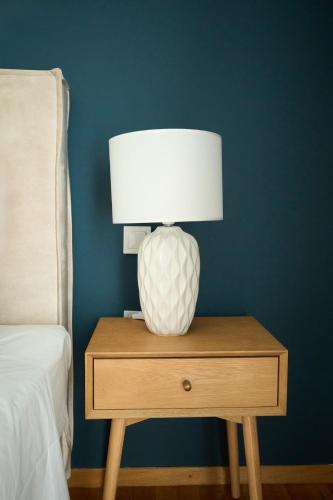 a lamp on a table next to a bed at Skye urban oasis in Tripolis