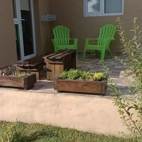 坦迪尔Cabaña zona Centinela的两把绿色椅子和天井上的长凳