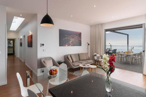 a living room with a glass table and chairs at OurMadeira - Vila da Portada in Funchal