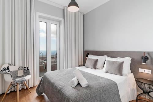 a bedroom with a bed and a chair and a window at OurMadeira - Vila da Portada in Funchal