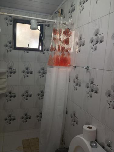 a bathroom with a shower curtain and a toilet at Silvana Viana Ribeiro Concon in Guarujá