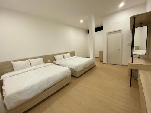 a hotel room with two beds and a mirror at Famille Hotel - Central hotel in Dalat in Xuan An