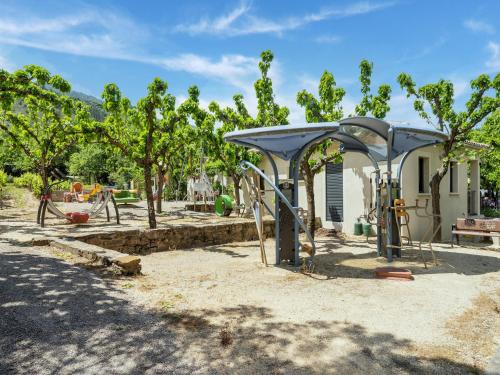 a park with a pavilion and trees in front of a house at Relaxing Family Stay in Les Vans in Chambonas