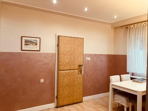 a room with a door and a table and a table and chairs at Lovely Garden 100m2 apartment in Novi Sad