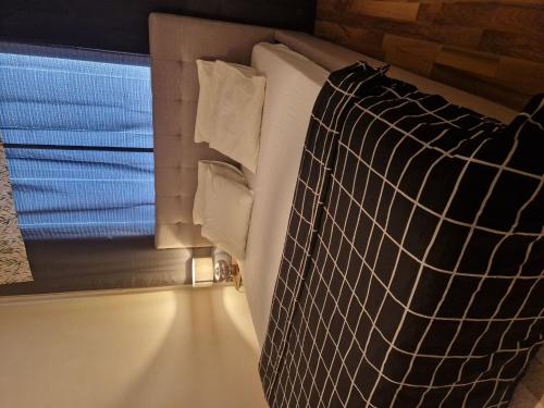 a bed with pillows and a window in a room at Relax in Lahtis Cozy Apartment in Lahti
