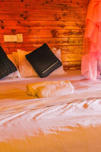 two beds in a room with wooden walls at New Bamboo Cabana Ella in Ella