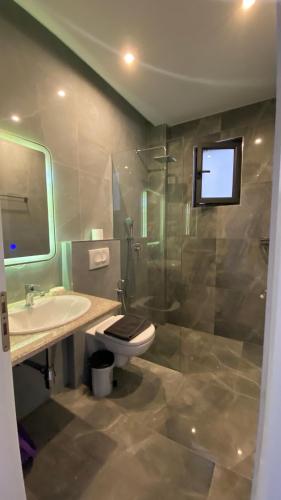 a bathroom with a toilet and a sink and a shower at Hotel Adriatik Ksamil in Ksamil